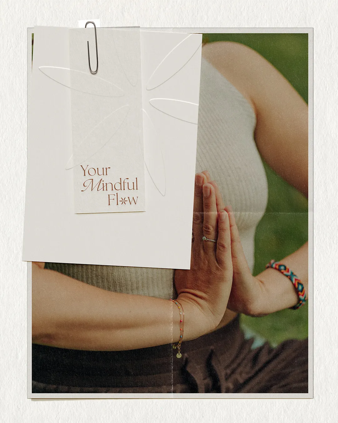 Papierkarte mit dem Logo von Your Mindful Flow vor einer Person mit Händen in Gebetshaltung
